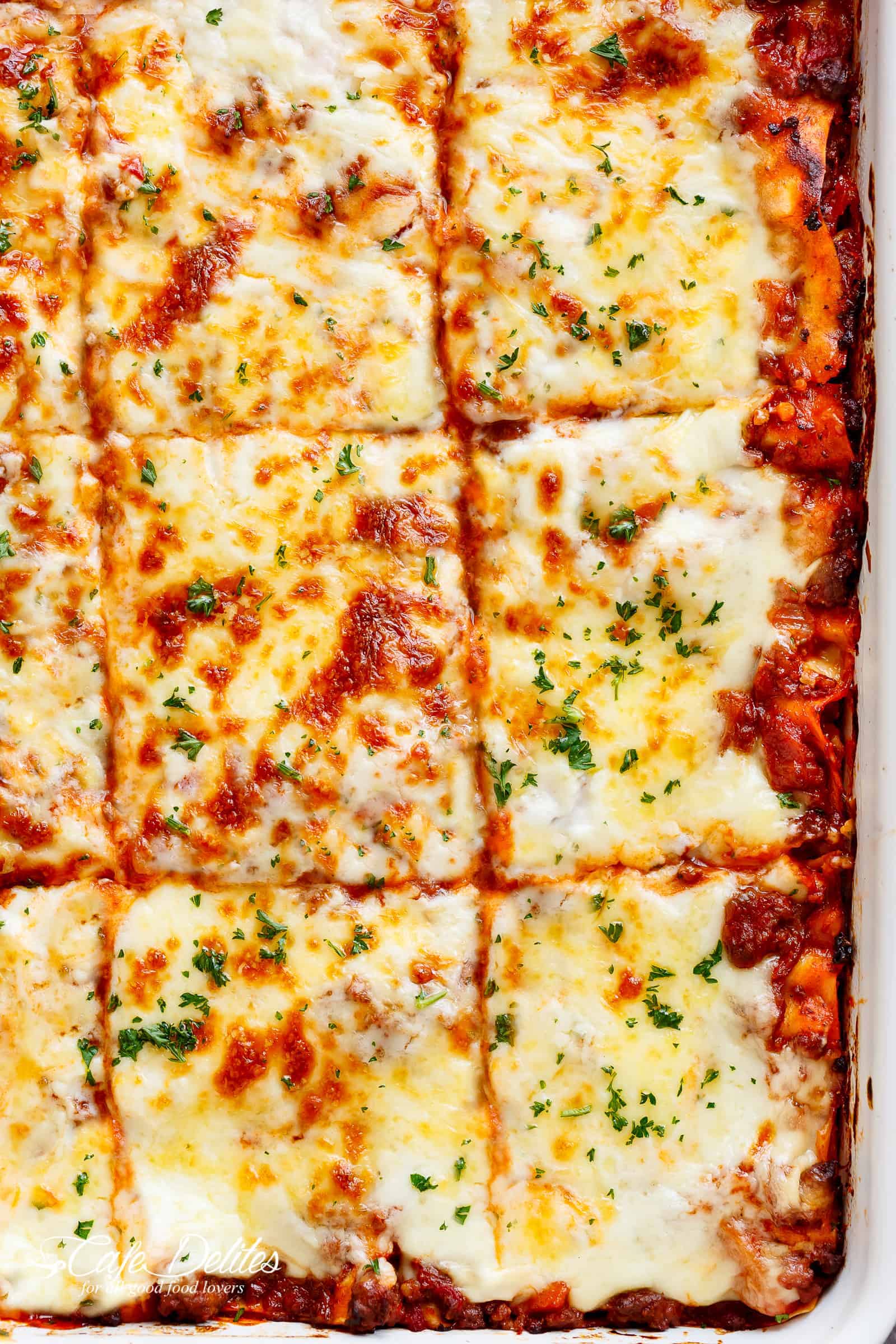 The Best Lasagna is here! Layered with a rich meat sauce and a creamy parmesan white sauce, plus the perfect amount of mozzarella cheese! NO ricotta cheese needed! | cafedelites.com