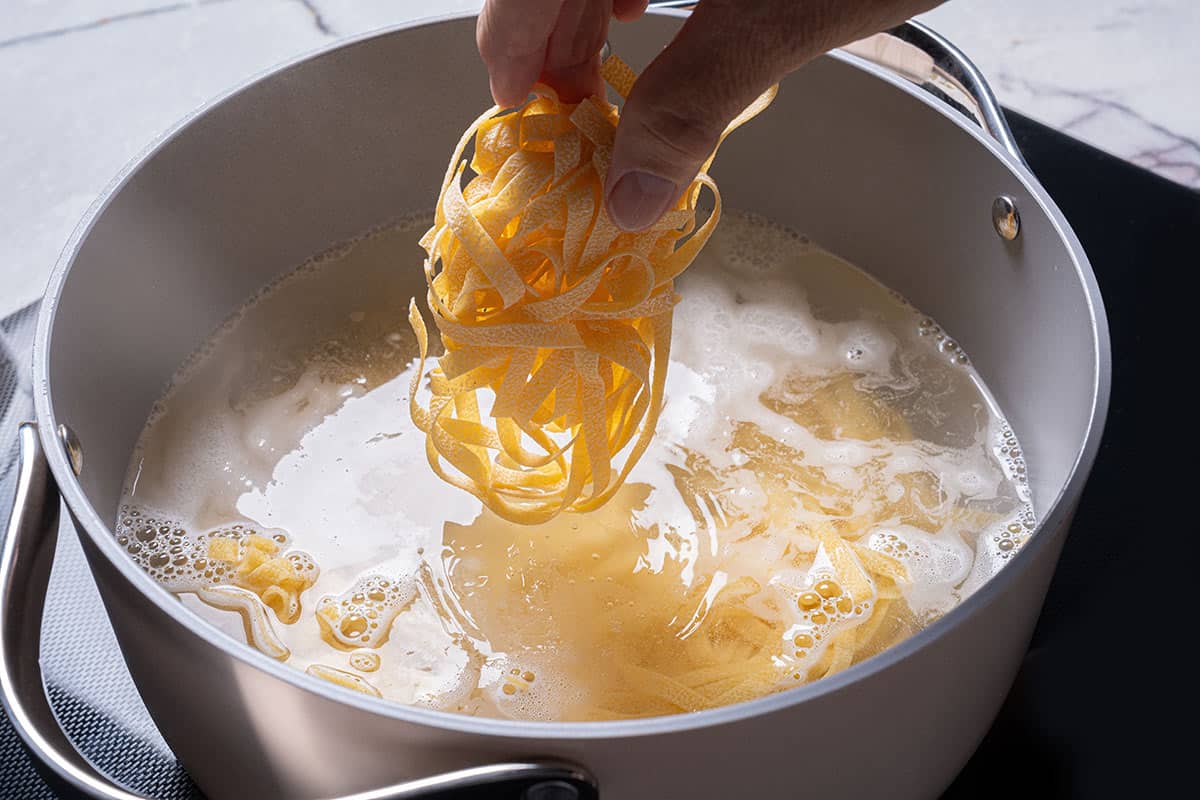 Pasta being immersed in boiling water.