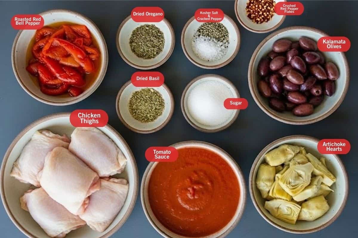 Flat lay photo of ingredient shot of roasted red bell pepper. dried oregano, dried basil, chicken thighs, tomato sauce, artichoke hearts, kalamata olives, crushed red pepper flakes, sugar, kosher salt, crushed pepper