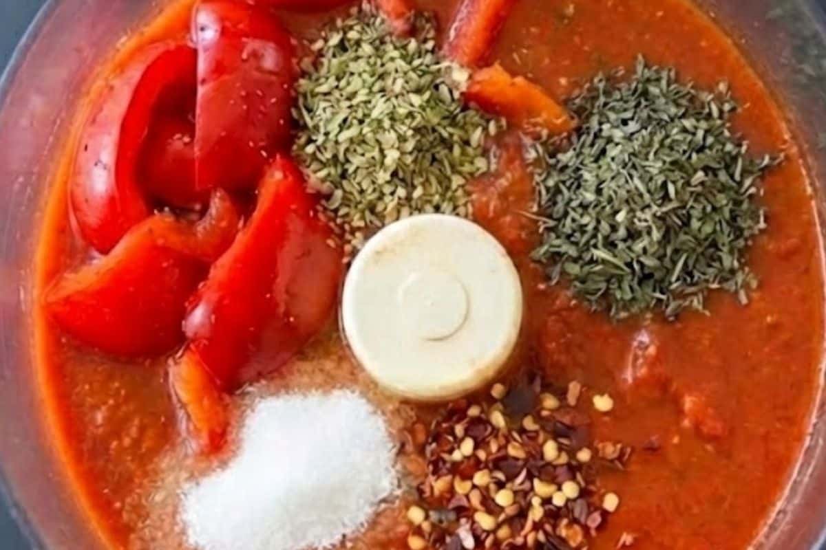 Add half of the red bell peppers, tomato sauce, oregano, basil, sugar, and red pepper flakes to a food processor then blend. - 3