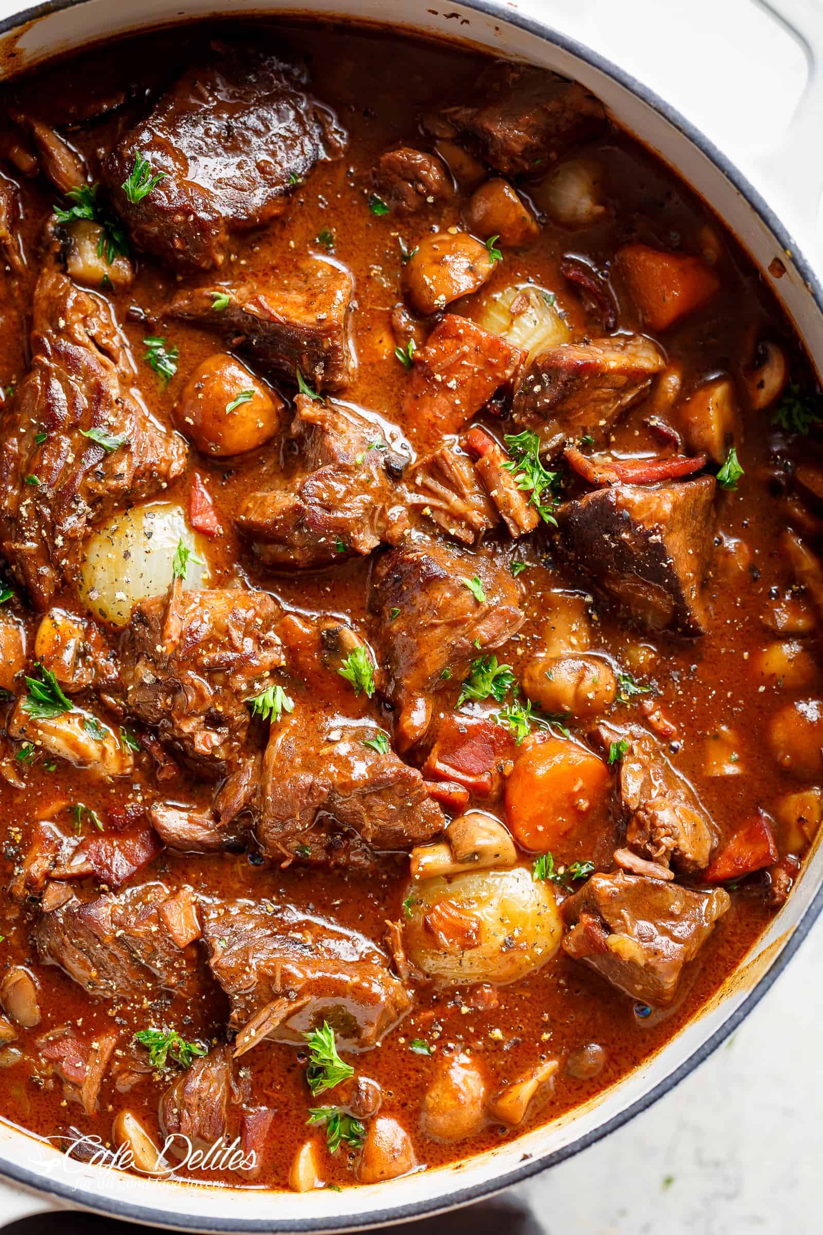 Tender fall apart chunks of beef simmered in a rich red wine gravy makes Julia Child's Beef Bourguignon an incredible family dinner. Slow Cooker, Instant Pot/Pressure Cooker, Stove Top and the traditional Oven method included! Easy to make, every step is worth it | cafedelites.com