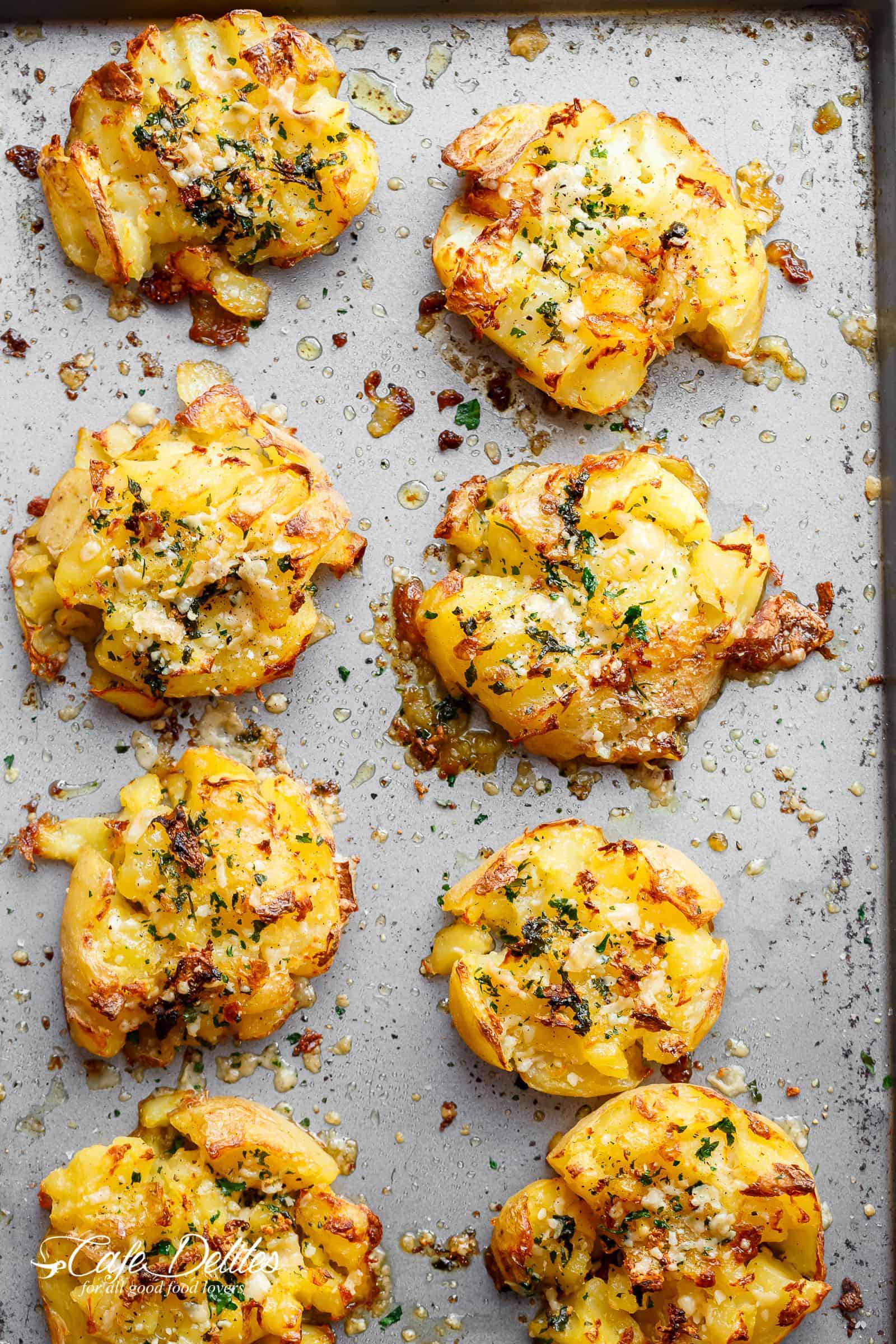 Crispy Garlic Butter Parmesan Smashed Potatoes are fluffy on the inside and crispy on the outside, smothered in garlic butter and melted parmesan cheese! Much like buttery and garlicky French fries or crispy hot chips. | https://cafedelites.com