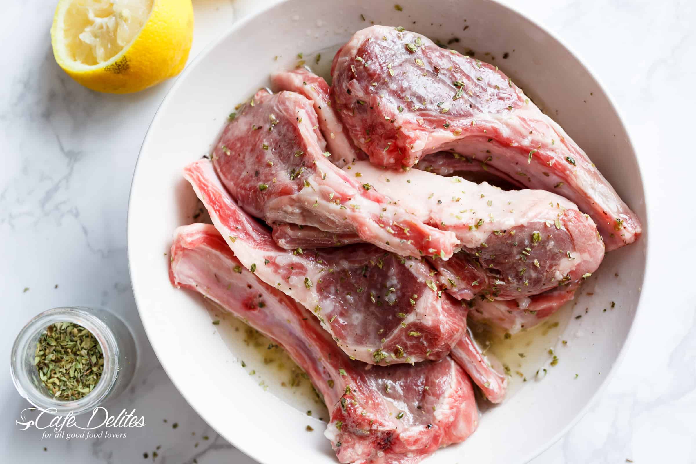 Raw meat in a bowl, marinating in seasoning and lemon juice. 