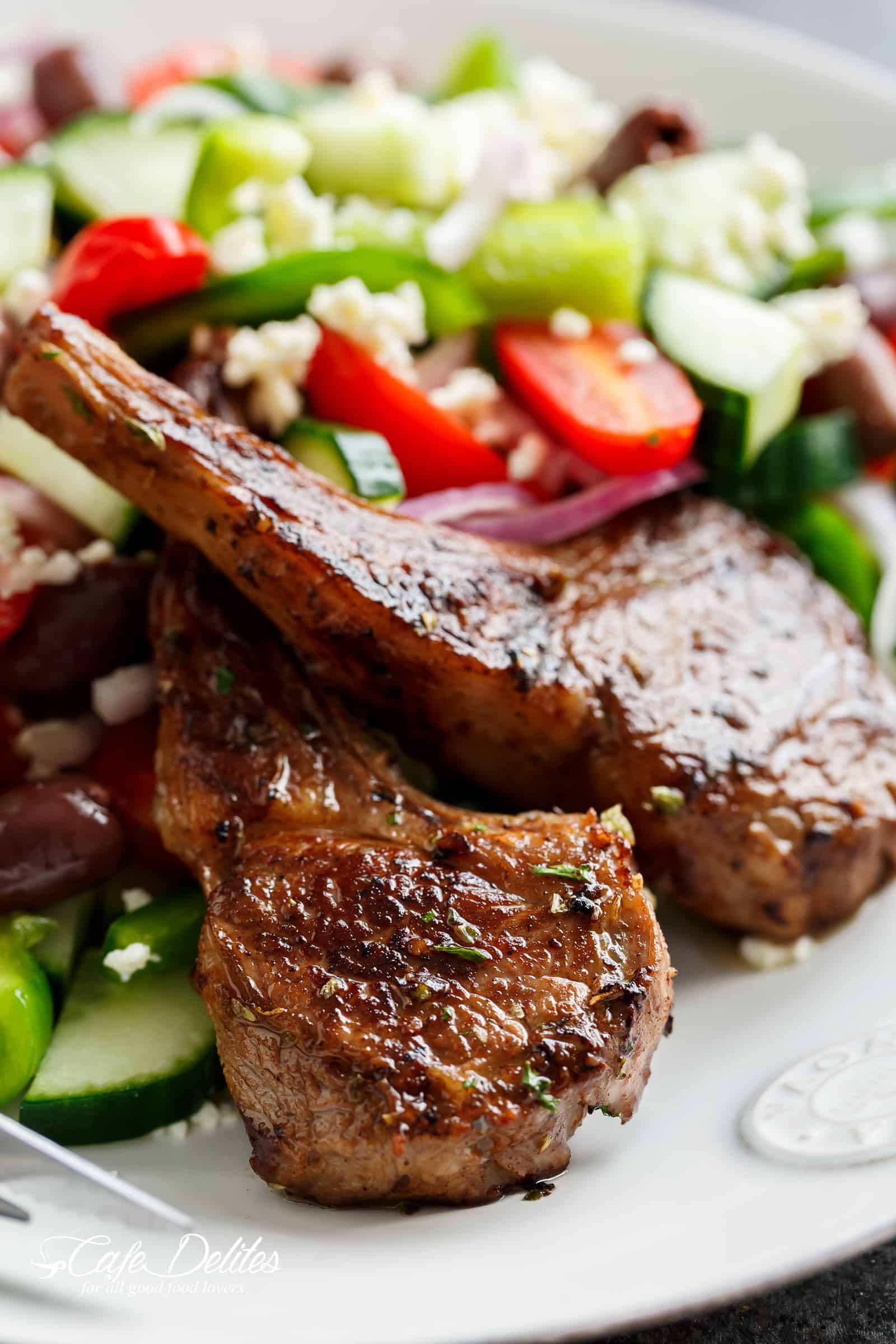 Finished lamb chops with a large side salad covered in crumbed feta. 