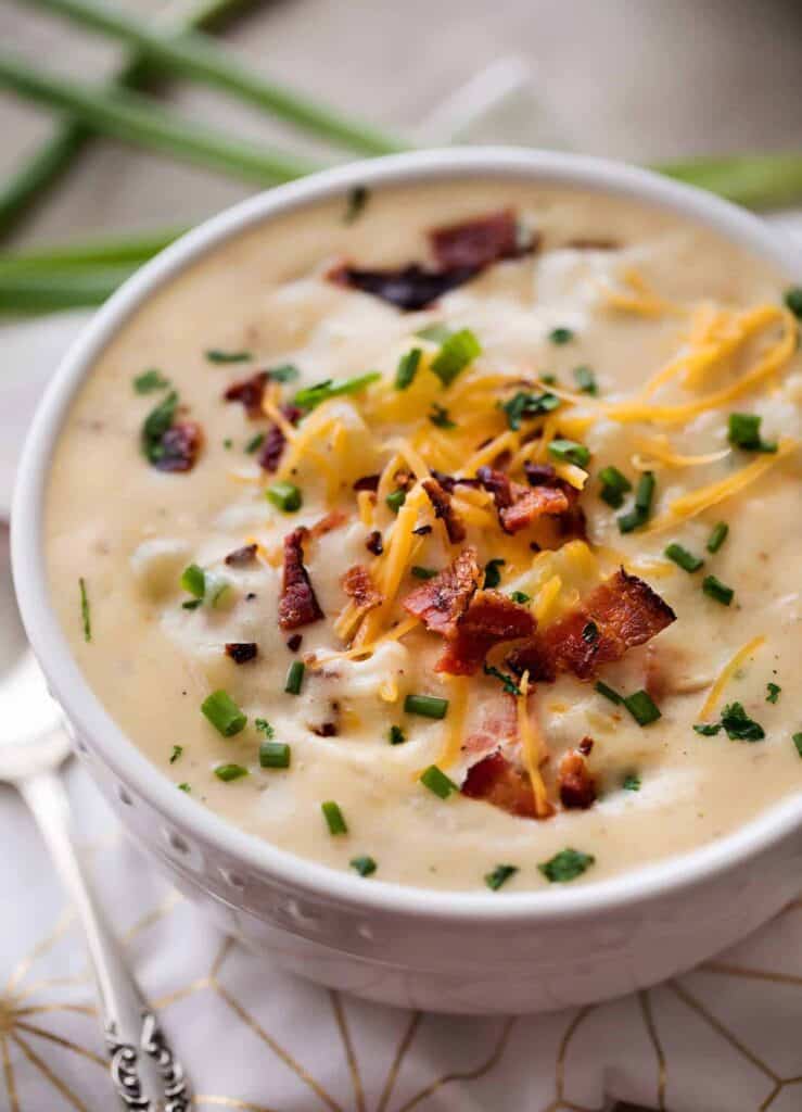 Skinny slow cooker potato soup in bowl with some shredded cheese