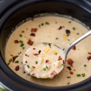 Ladle of skinny slow cooker potato soup from a bowl