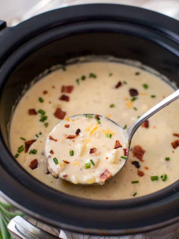 Ladle of skinny slow cooker potato soup from a bowl
