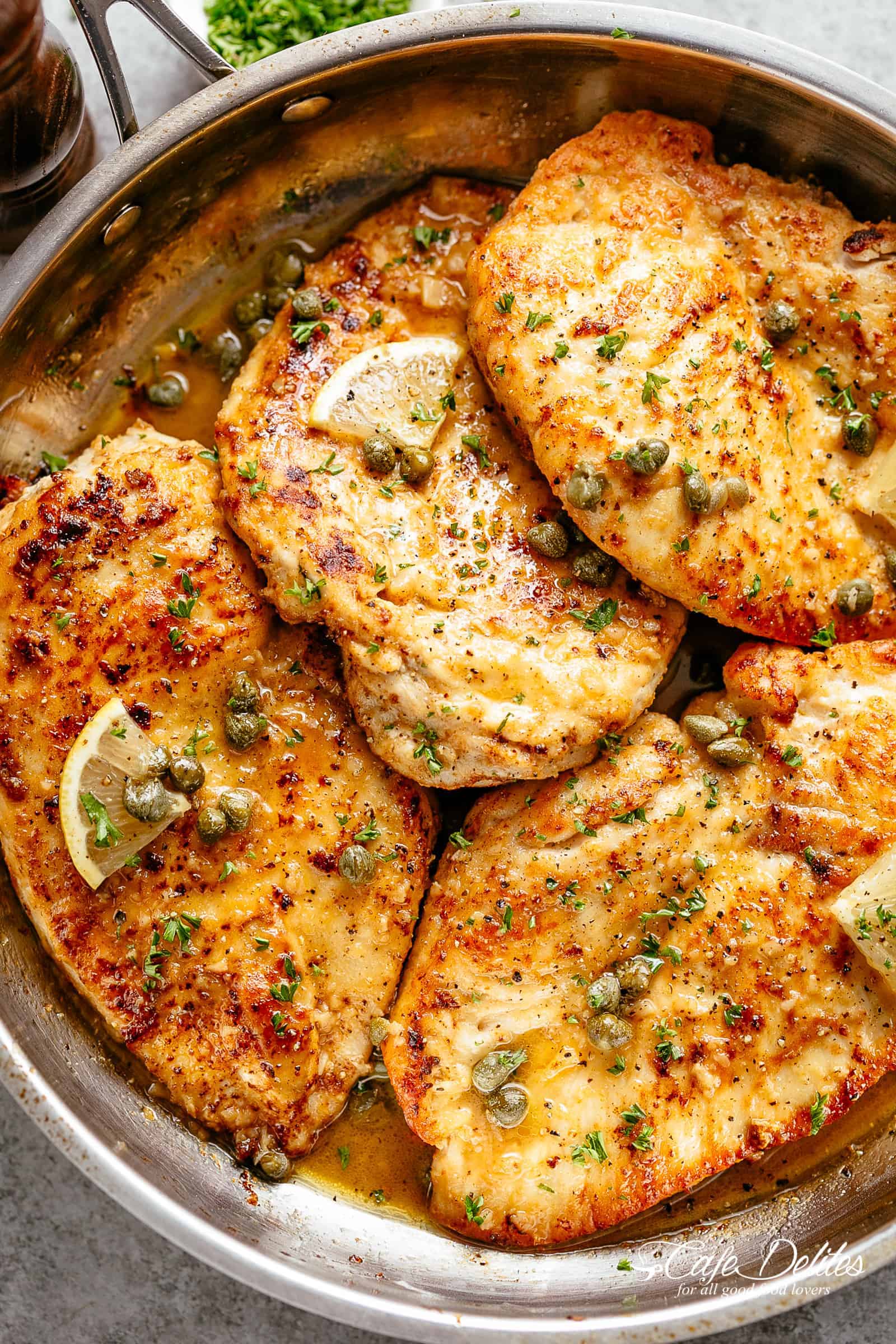 Garlic Chicken Piccata is an easy family favourite recipe adding a garlic twist to an authentic Piccata! Chicken lightly dusted with flour and parmesan cheese, lightly fried until a soft golden crust forms and finished off in a buttery, silky, lemon garlic sauce with capers and white wine or stock! | cafedelites.com