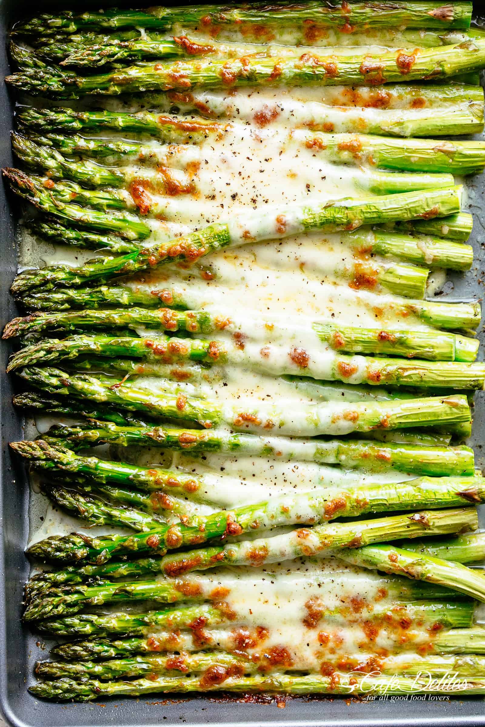 Tray of cooked cheesy garlic roasted asparagus.