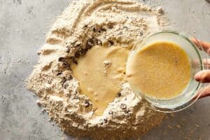 wet ingredients being mixed into chocolate chip dough