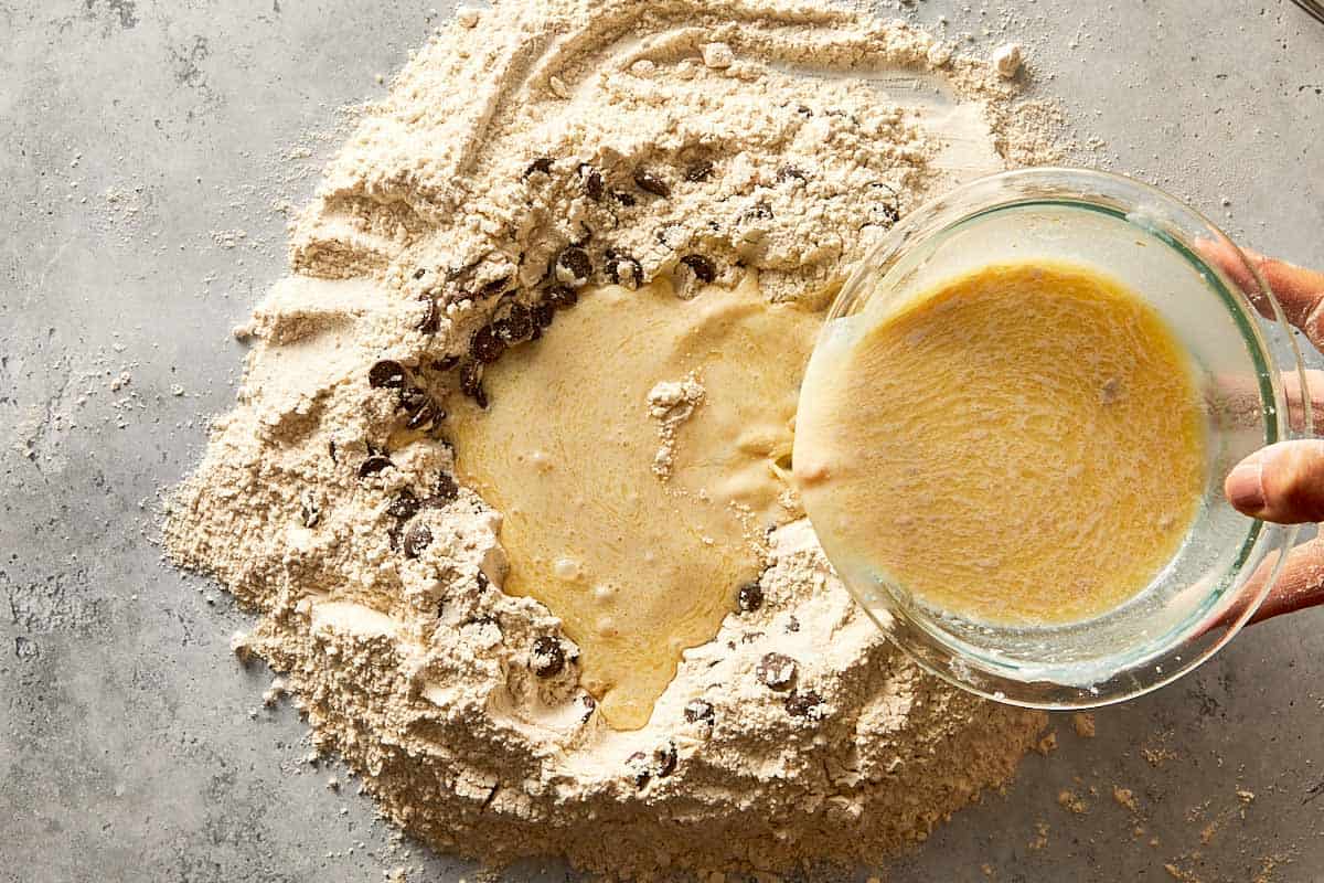 wet ingredients being mixed into chocolate chip dough