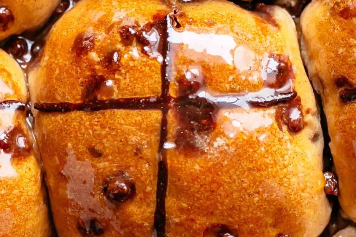 Pipe melted chocolate crosses onto warm buns, brush with apricot glaze