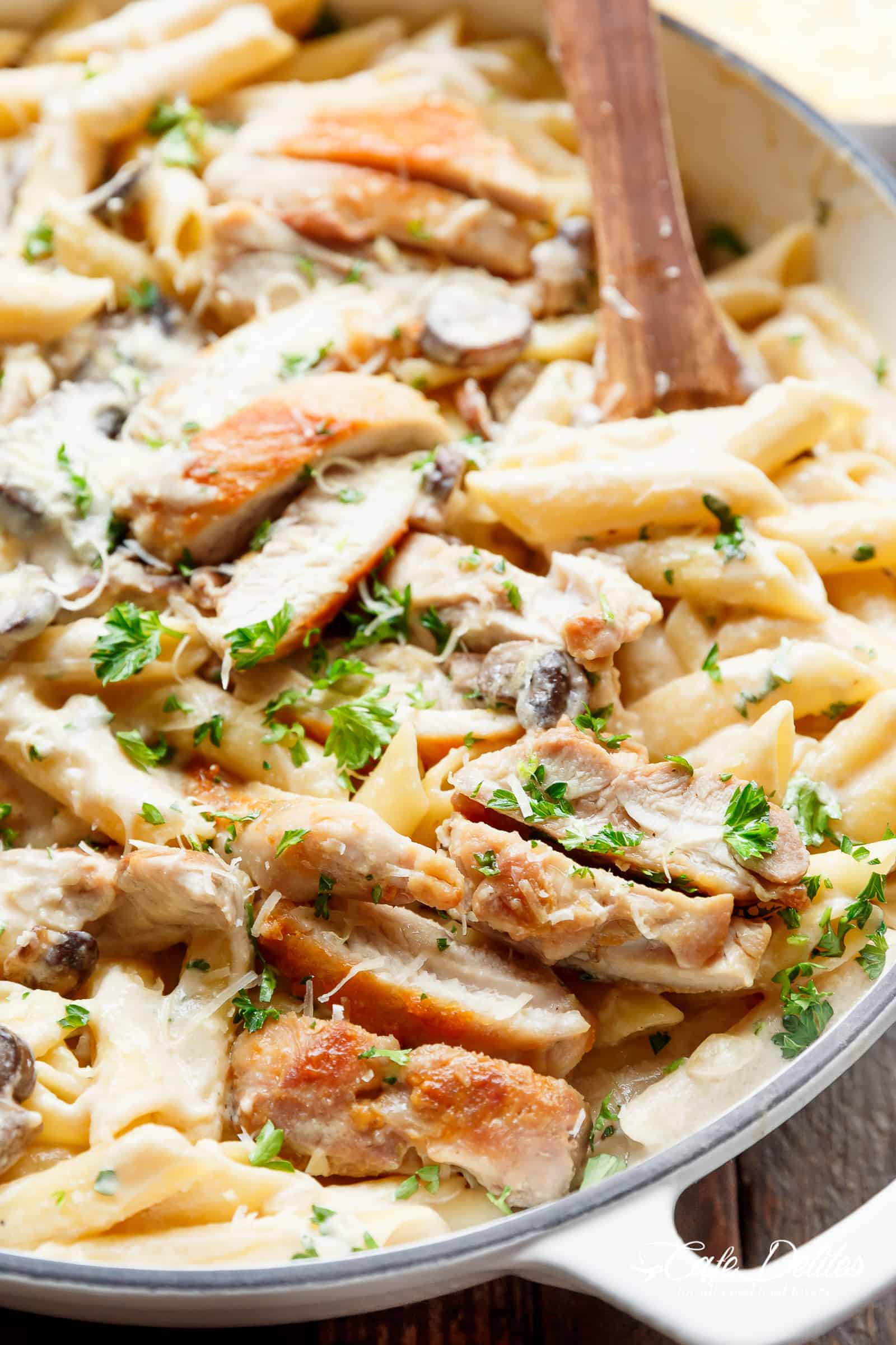 Creamy Garlic Parmesan Chicken Alfredo is all cooked in ONE POT! Ready and on the table in less than 20 minutes! Seared chicken is mixed through a super creamy garlic parmesan flavoured pasta with white wine and mushrooms! A favourite Chicken Alfredo recipe! | cafedelites.com