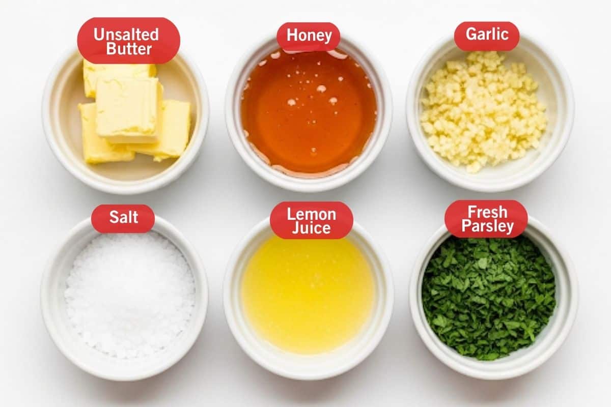Flay lay photo of ingredient shot of unsalted butter, honey, garlic, salt, lemon juice, fresh parsley.