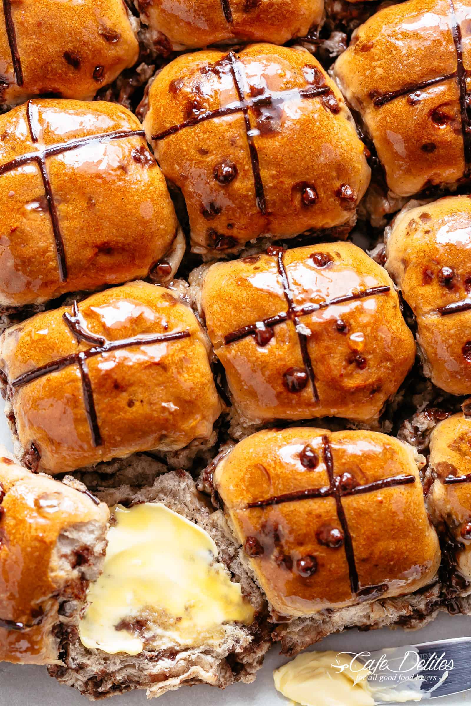 Fluffy and fragrant homemade hot cross buns filled with melted chocolate chips to please the kids as well as the adults! Better than store bought, there's just something about warm and fresh homemade breads! The best part? No proofing yeast! This recipe is so easy! | cafedelites.com
