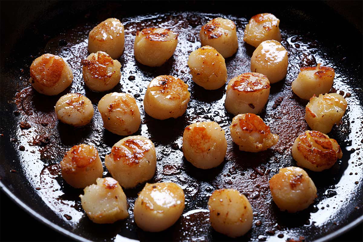 Image of scallops being fried in a pan over medium heat.