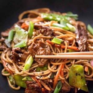 Beef stir fry noodles in bowl with chopsticks
