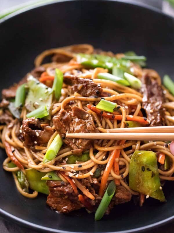 Beef stir fry noodles in bowl with chopsticks