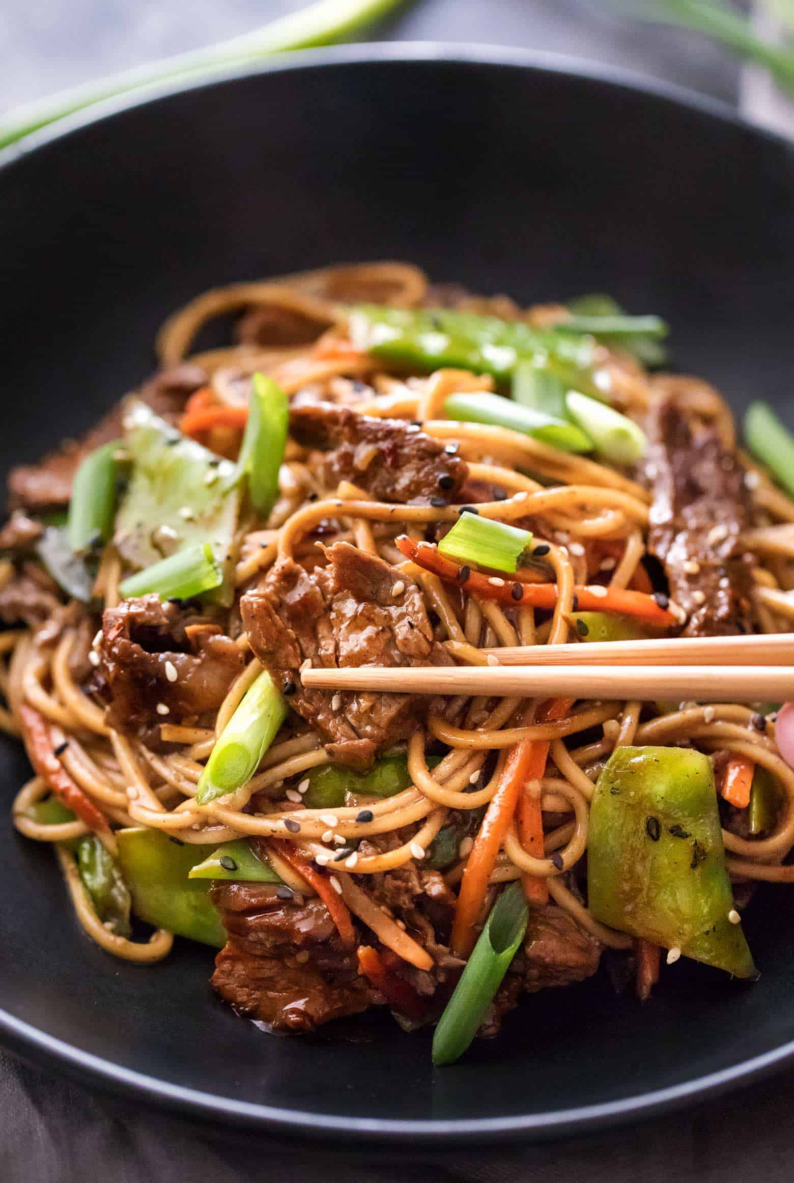 Beef stir fry in bowl with chopsticks