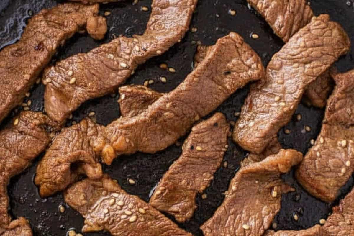 Searing the steak in a skillet.