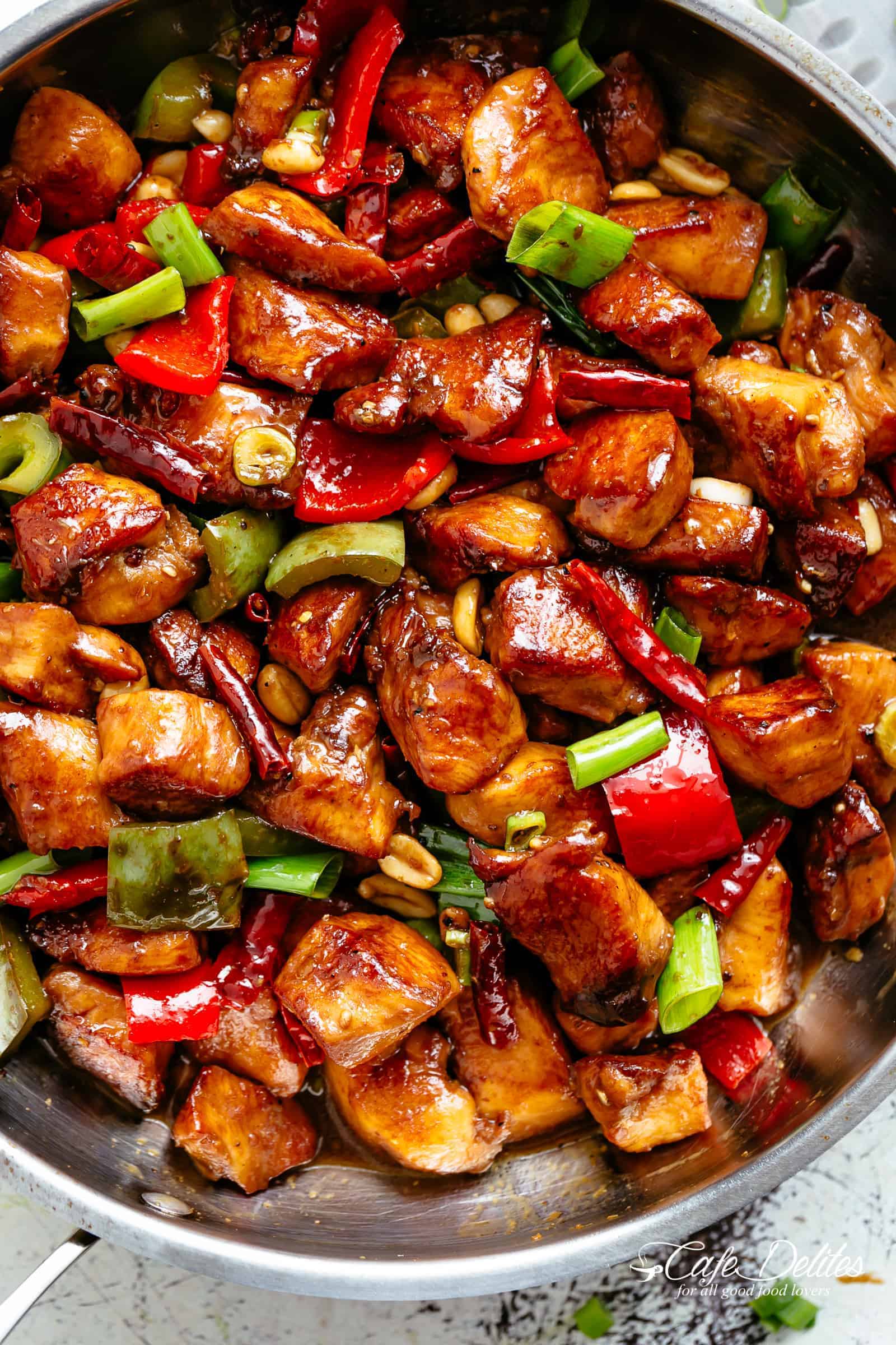 Kung Pao Chicken is highly addictive stir-fried chicken with the perfect combination of salty, sweet and spicy flavour! Make it better than Chinese take out right at home! With crisp-tender chicken pieces and some crunchy veggies thrown in, this is one Kung Pao chicken recipe hard to pass up!  | cafedelites.com