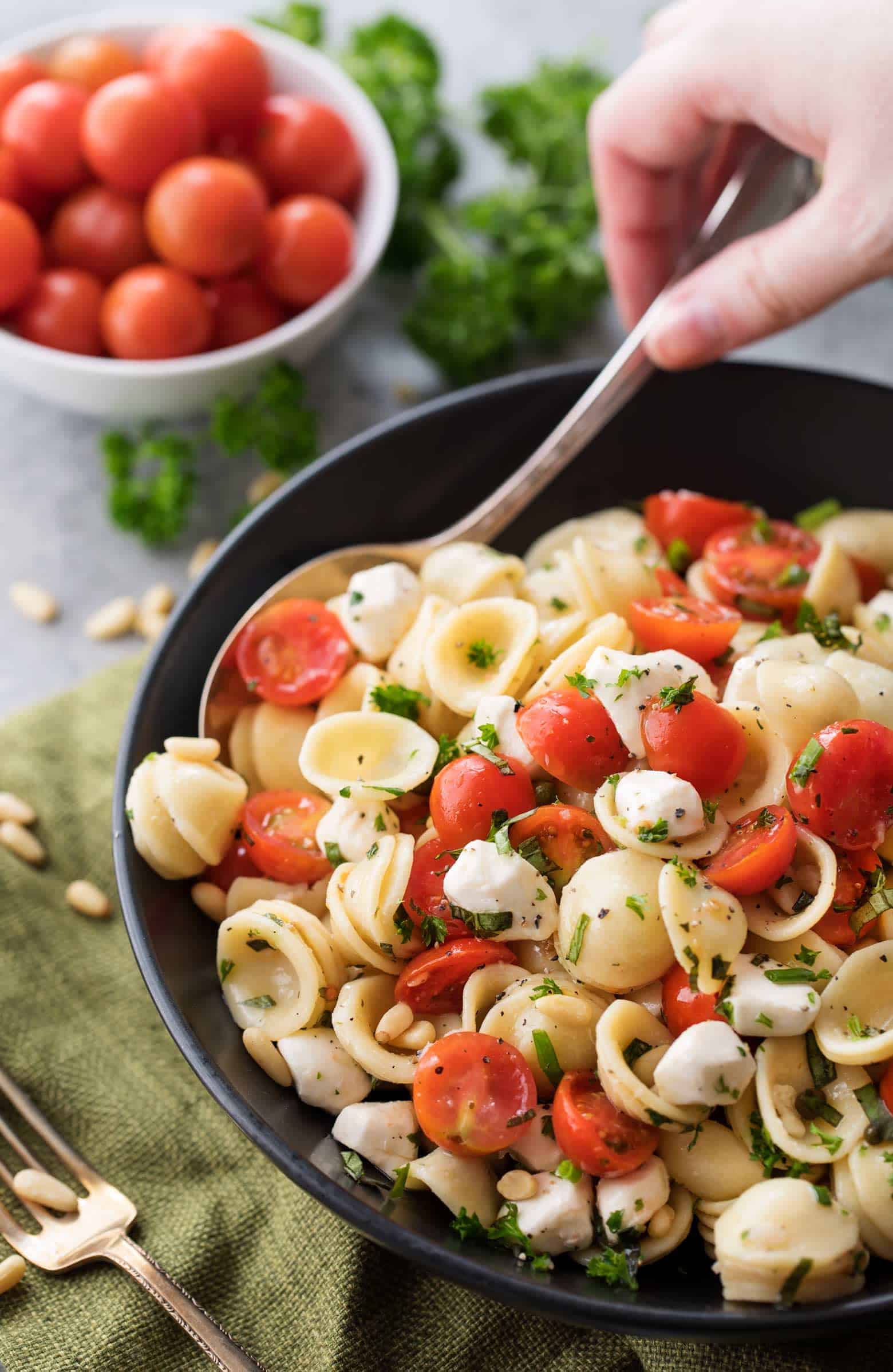 The perfect Caprese pasta salad for a potluck or summer bbq! Caprese pasta salad made with juicy tomatoes, marinated fresh mozzarella cheese, fragrant fresh basil, and a mouthwatering homemade Italian herb vinaigrette! A versatile popular side dish! | cafedelites.com