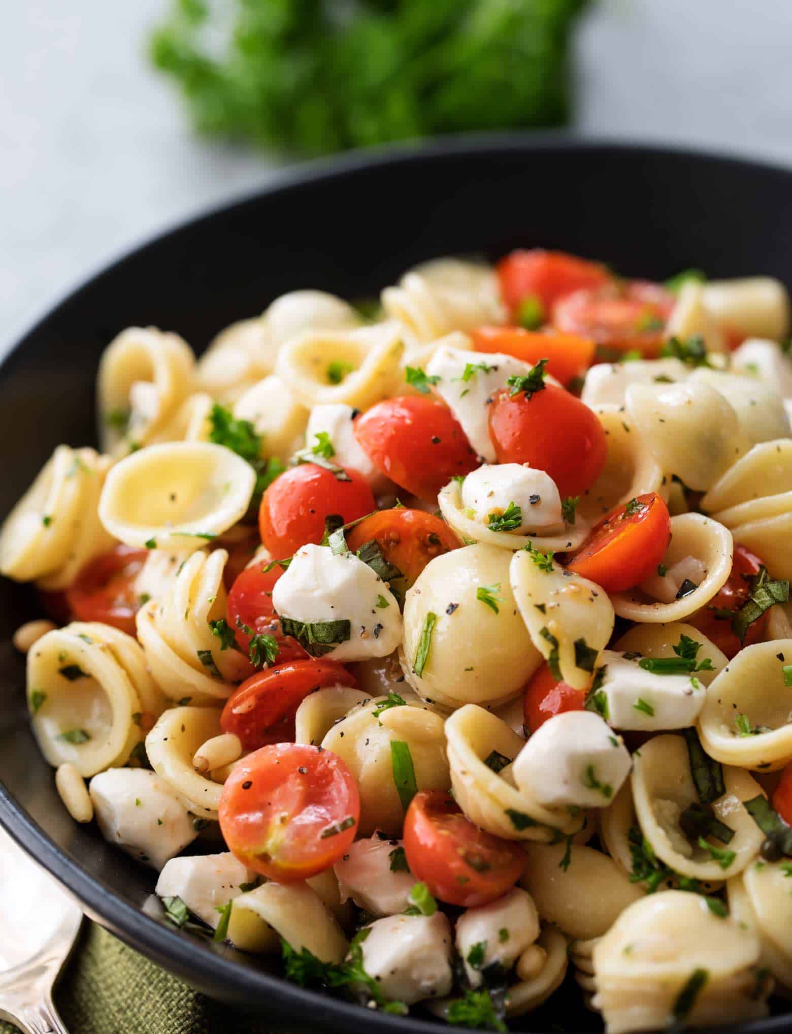 The perfect Caprese pasta salad for a potluck or summer bbq! Caprese pasta salad made with juicy tomatoes, marinated fresh mozzarella cheese, fragrant fresh basil, and a mouthwatering homemade Italian herb vinaigrette! | cafedelites.com