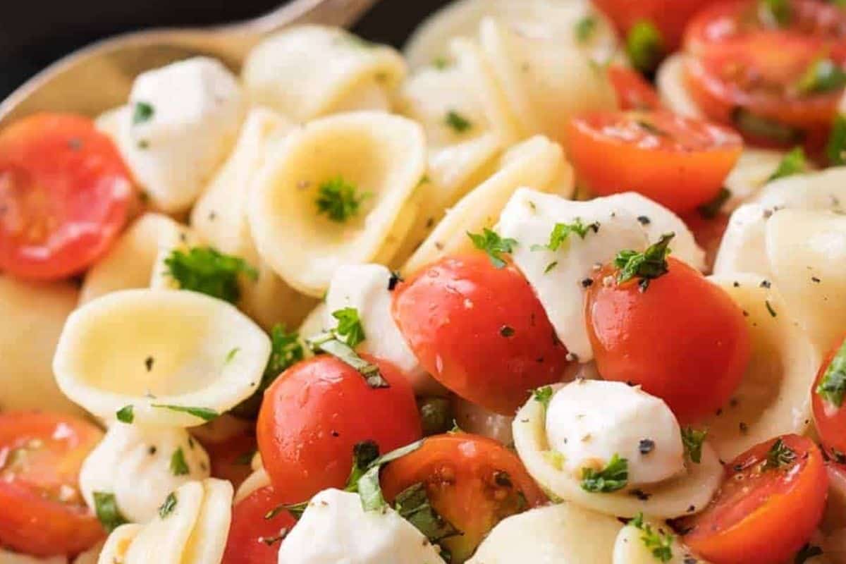 Once the pasta is cooled, add it to the bowl with the marinated tomatoes and mozzarella.