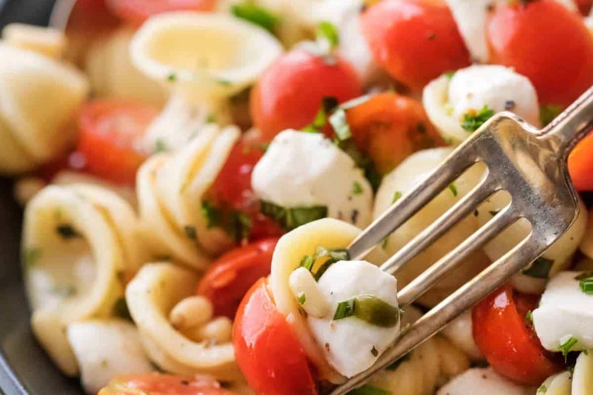 Drizzle the reserved dressings over the salad and toss. Garnish with extra basil and pine nuts.