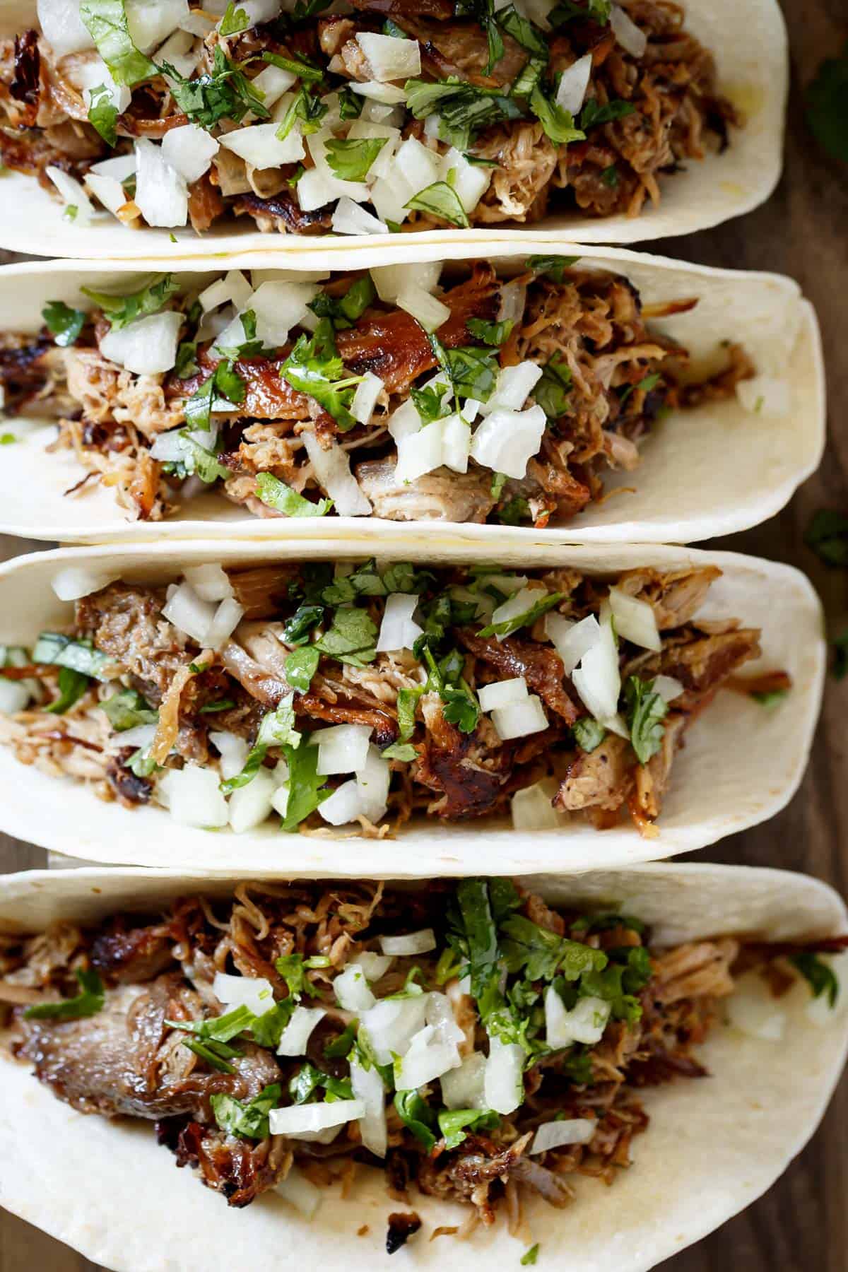 Crispy Pork Carnitas in flour tortillas. The closest recipe to authentic Mexican Carnitas (NO LARD), with a perfect crisp finish! | https://cafedelites.com