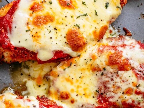 The Best Chicken Parmesan with a deliciously crispy breadcrumb coating, smothered in a rich homemade tomato sauce and melted mozzarella cheese! This is here best Chicken Parmesan you will ever make! Simple to make and worth every minute. If you love a crispy crumb coating vs soggy crumb, look no further!