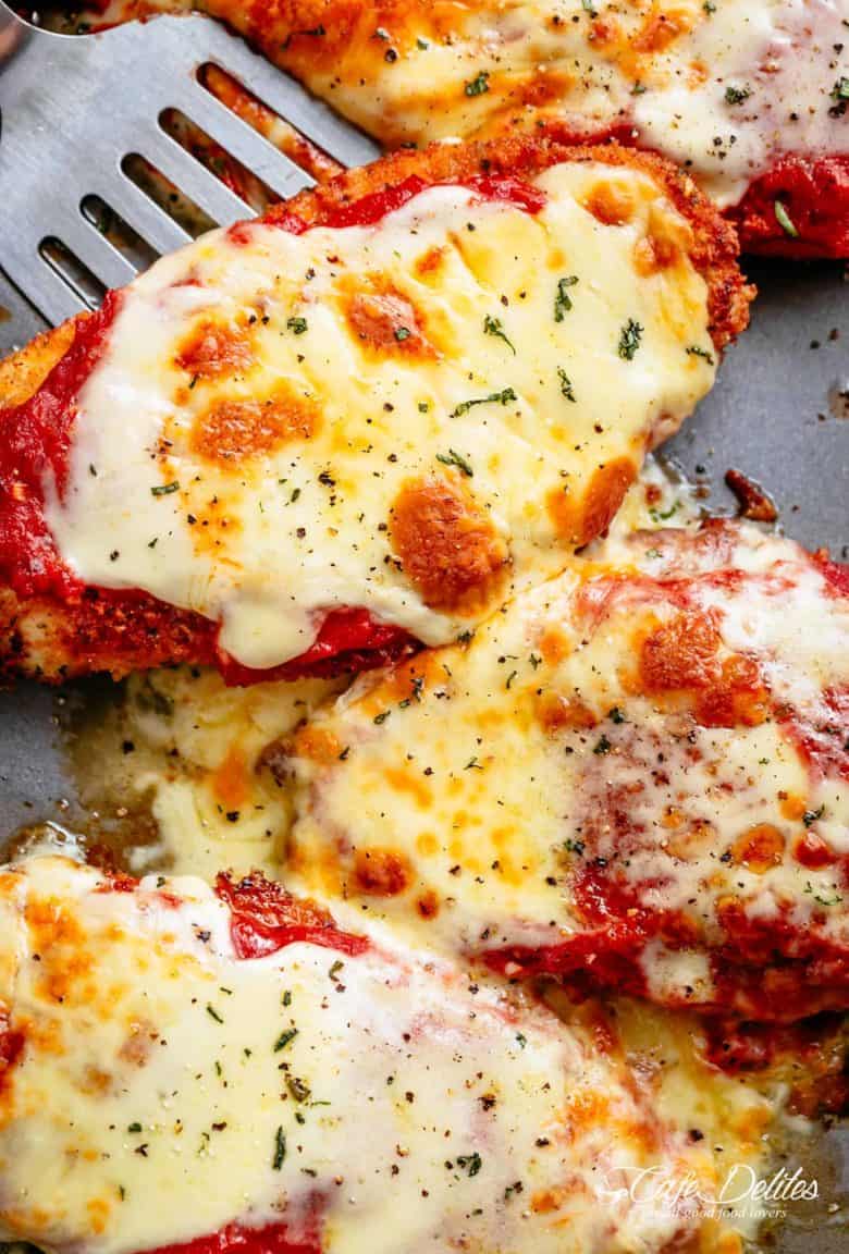 The Best Chicken Parmesan with a deliciously crispy breadcrumb coating, smothered in a rich homemade tomato sauce and melted mozzarella cheese! This is here best Chicken Parmesan you will ever make! Simple to make and worth every minute. If you love a crispy crumb coating vs soggy crumb, look no further! | cafedelites.com