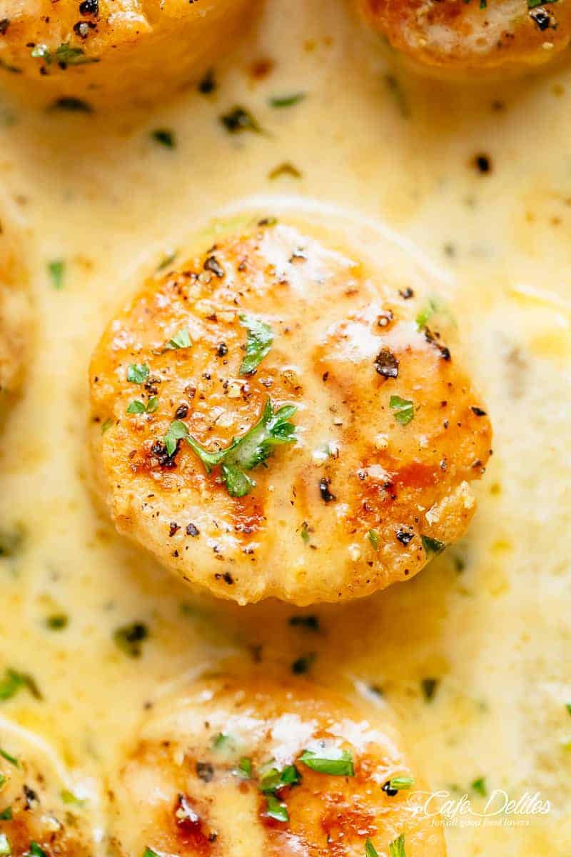 Creamy Garlic Scallops are just as good as restaurant scallops with minimal ingredients and maximum flavour! A silky, creamy garlic sauce with a hint of lemon coats crispy, buttery scallops! With only a handful of ingredients, you're minutes away from having the most incredible scallops on your dinner table! | cafedelites.com