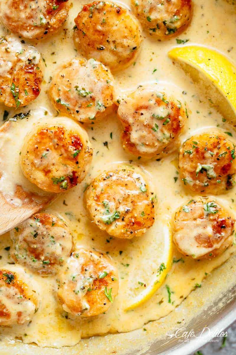 Creamy Garlic Scallops is just as good as restaurant scallops with minimal ingredients and maximum flavients! レモンの香りがする絹のようなクリーミーなガーリックソースが、カリッとしたバター風味のホタテをコーティングしてくれます わずかな材料で、最高のホタテを食卓に。 | cafedelites.com