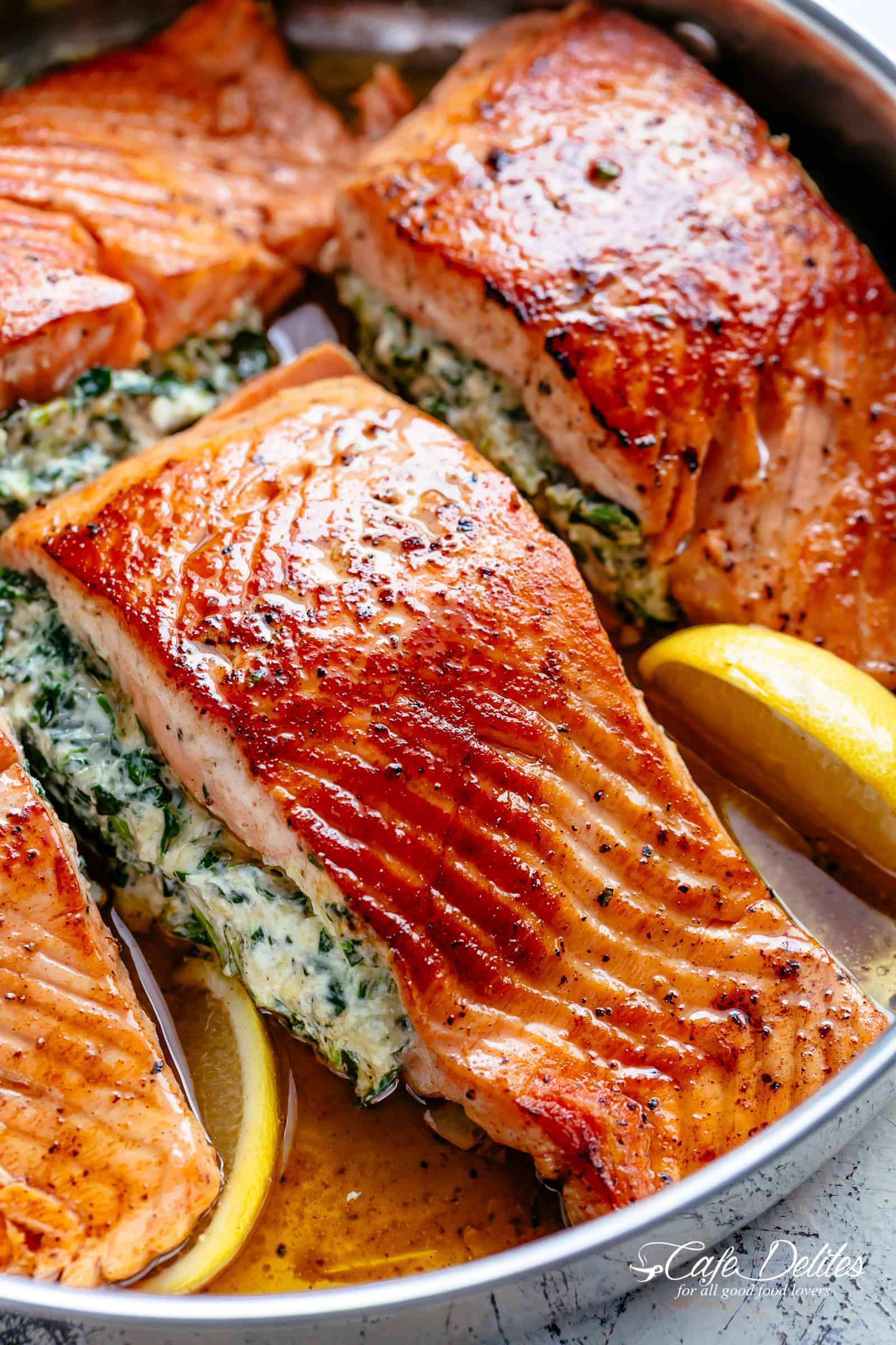 Creamy Spinach Stuffed Salmon in garlic butter is a new delicious way to enjoy salmon! Filled with cream cheese, spinach, parmesan cheese and garlic, this salmon beats than anything found in a restaurant. Your new favourite salmon recipe includes pan fried AND oven baked methods! | cafedelites.com