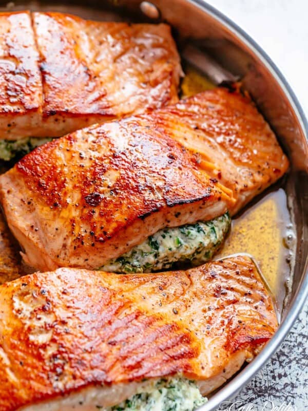 Creamy Spinach Stuffed Salmon in garlic butter is a new delicious way to enjoy salmon! Filled with cream cheese, spinach, parmesan cheese and garlic, this salmon beats than anything found in a restaurant.