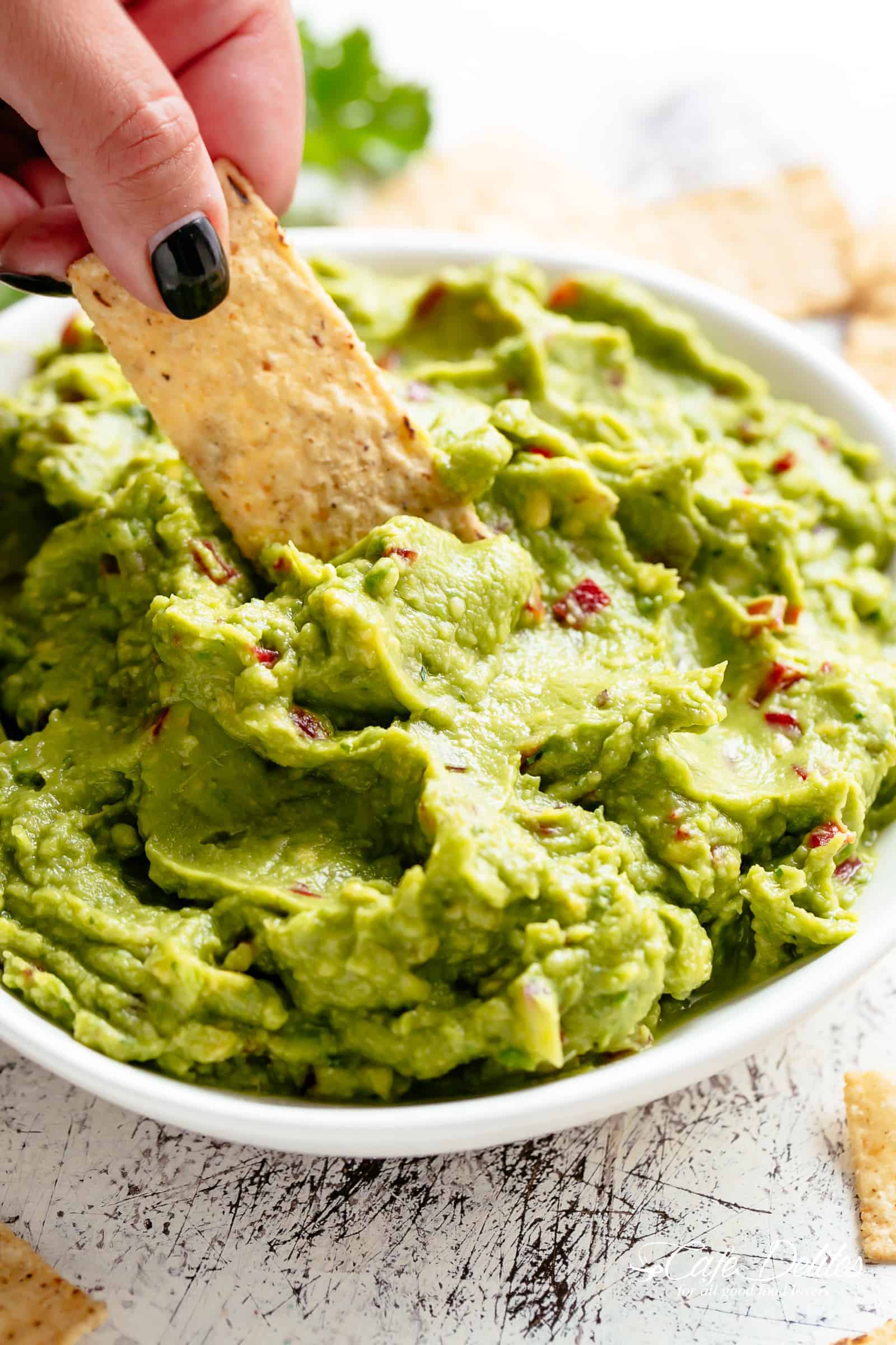 The best, creamy Guacamole is so easy to make and better than anything found in a jar! Homemade Guacamole takes minutes to make and is so incredibly delicious! Perfect for a party as an appetizer OR just a simple snack! Use as a topping for your favourite fajitas, tacos and even carnitas! | cafedelites.com