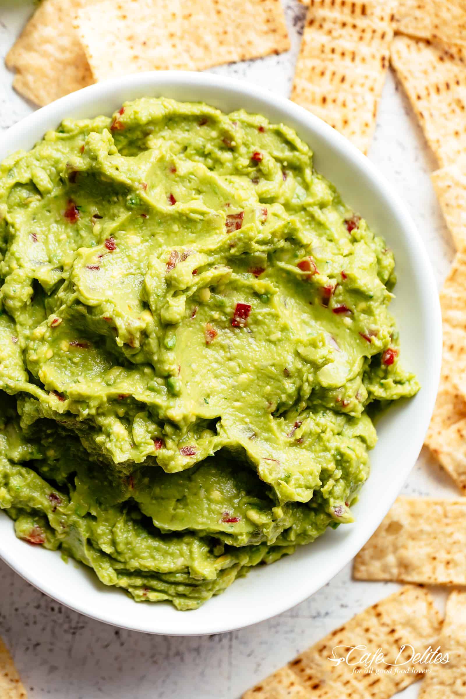 The best, creamy Guacamole is so easy to make and better than anything found in a jar! Homemade Guacamole takes minutes to make and is so incredibly delicious! Perfect for a party as an appetizer OR just a simple snack! Use as a topping for your favourite fajitas, tacos and even carnitas! | cafedelites.com