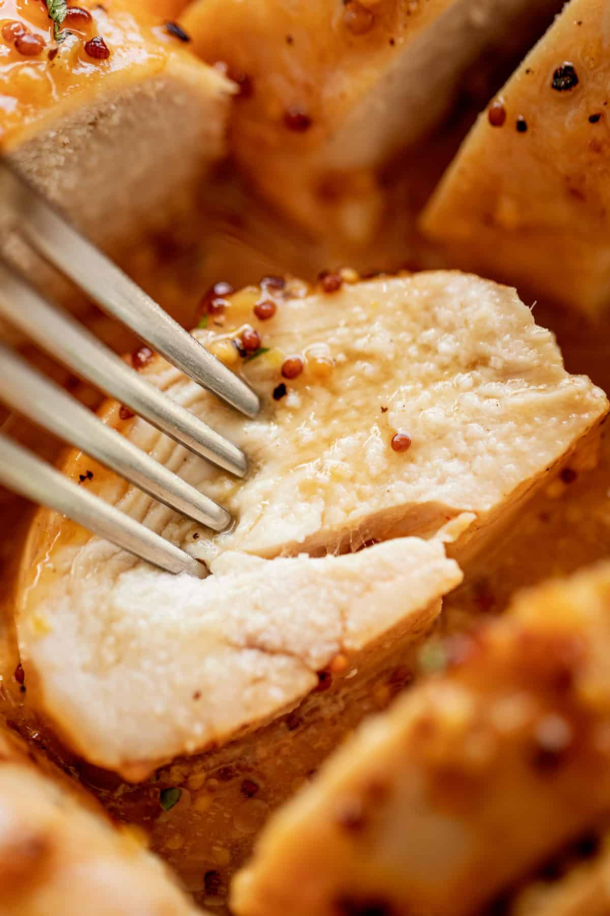 A slice of tender and juicy Baked Chicken Breasts with a delicious honey mustard sauce | cafedelites.com