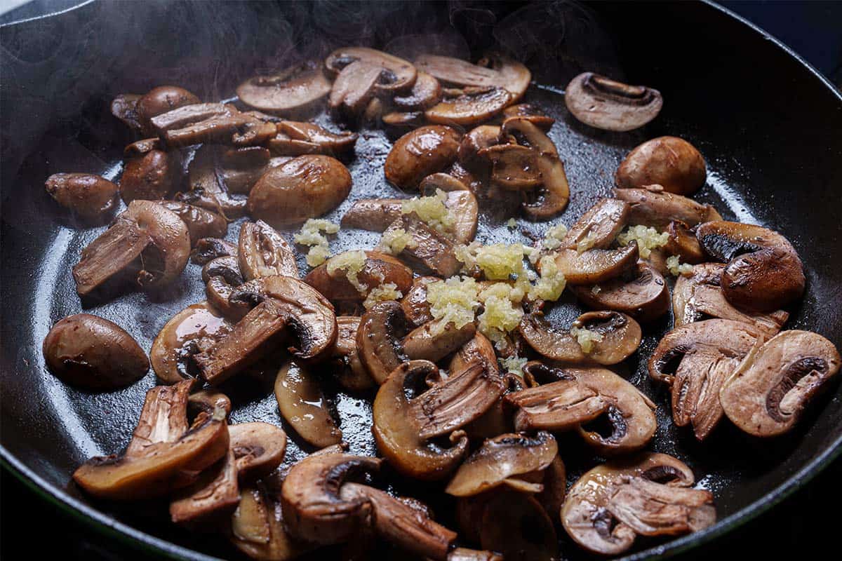 An image of garlic being added to the pan and cooked until fragrant for about one minute.