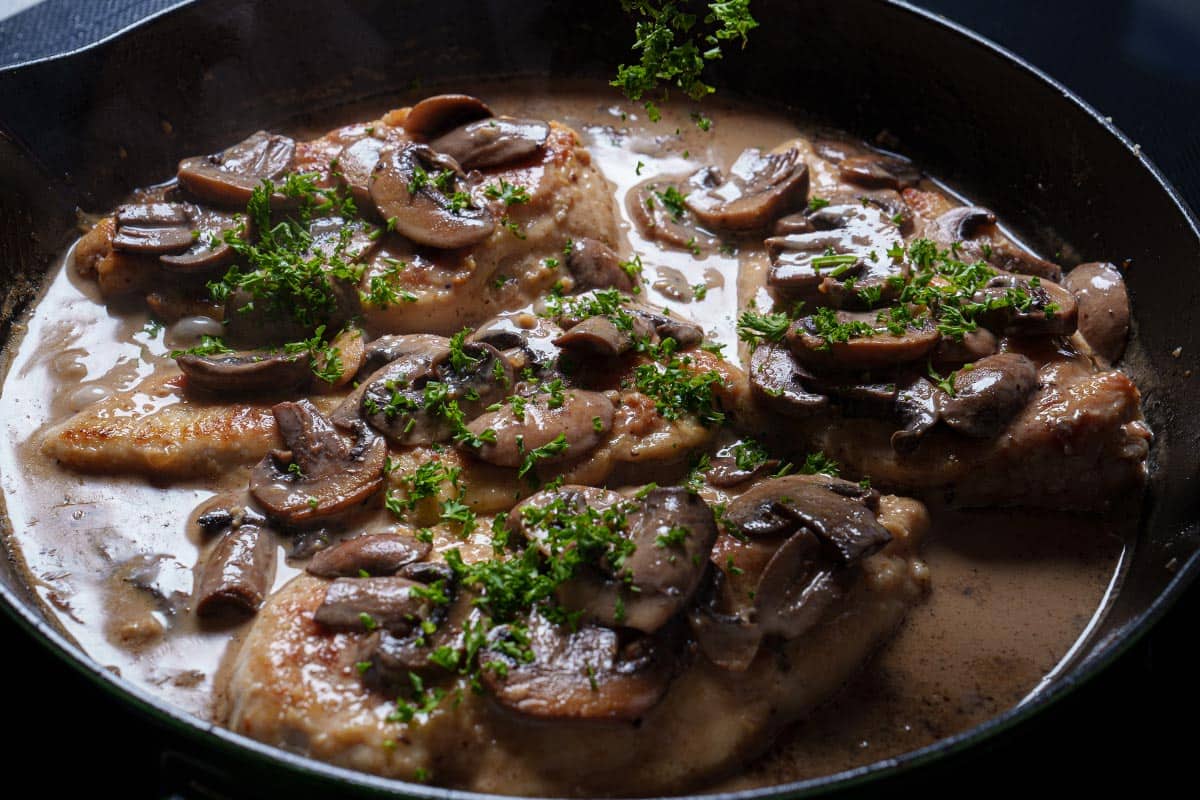 Image of the chicken being returned to the pan to finish cooking.