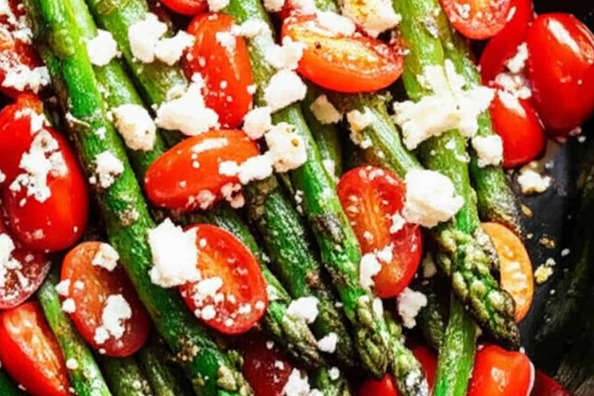 Cooked asparagus topped with cherry tomatoes and feta cheese.