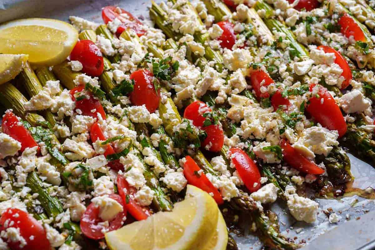 asparagi topped with tomato and feta cheese ready to be enjoyed.