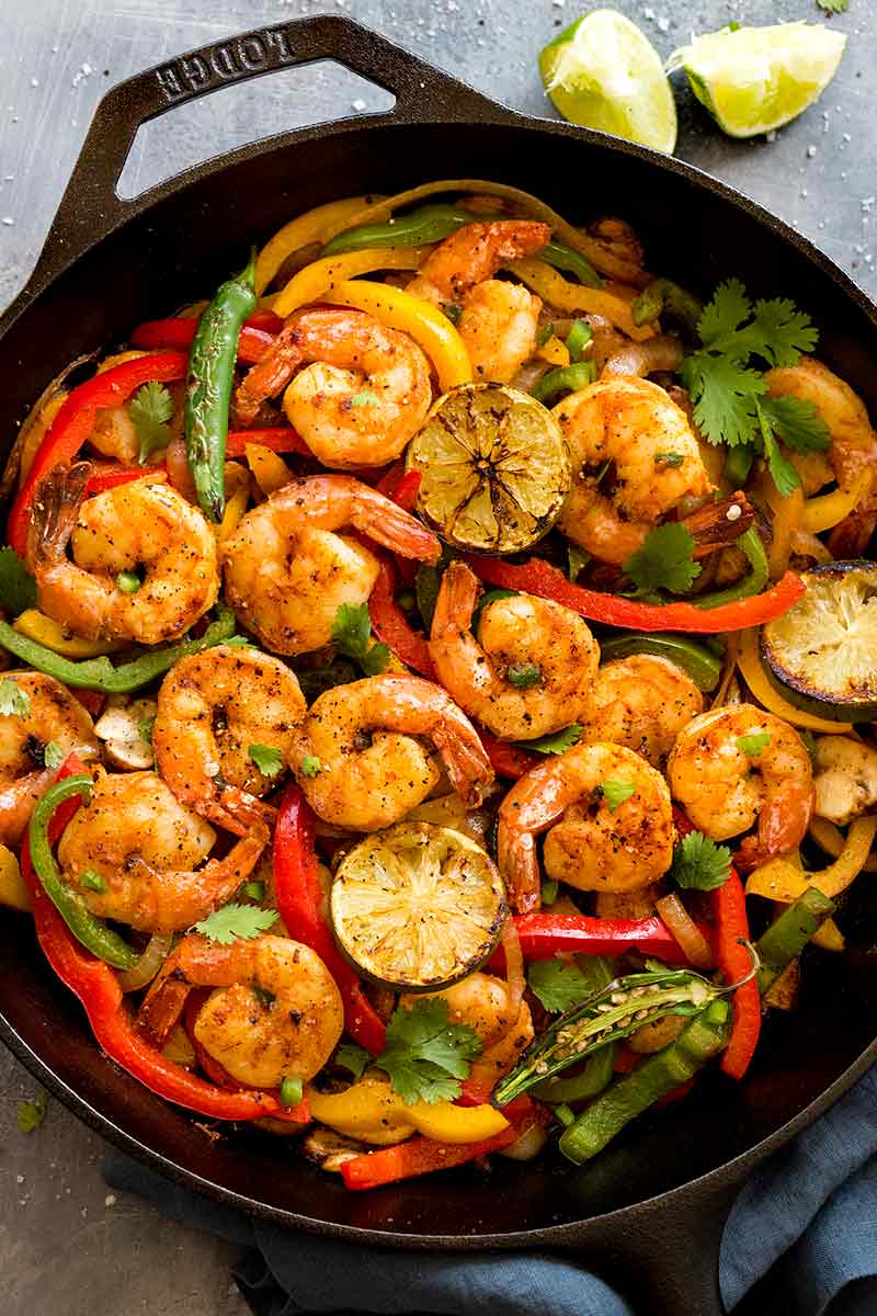 spicy shrimp fajitas cooking in a cast iron skillet