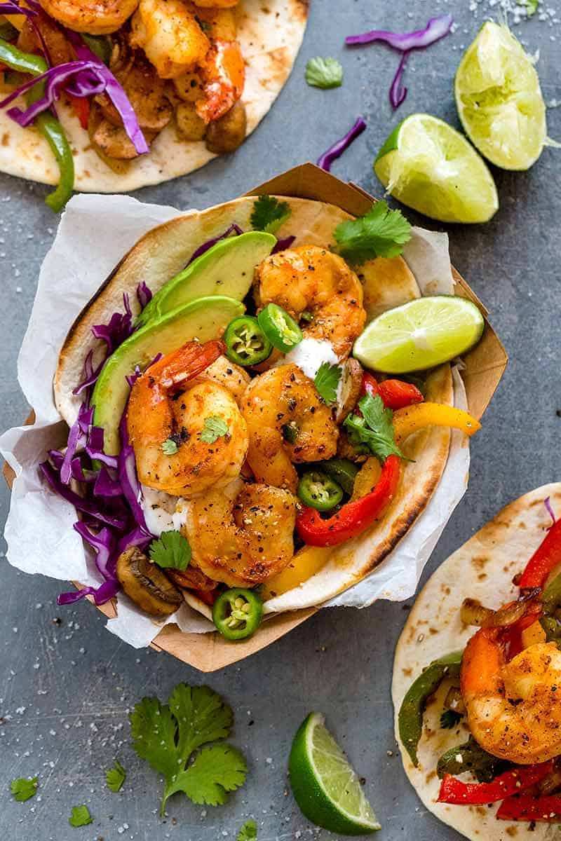 spicy shrimp fajita tacos served in paper trays with lime wedges