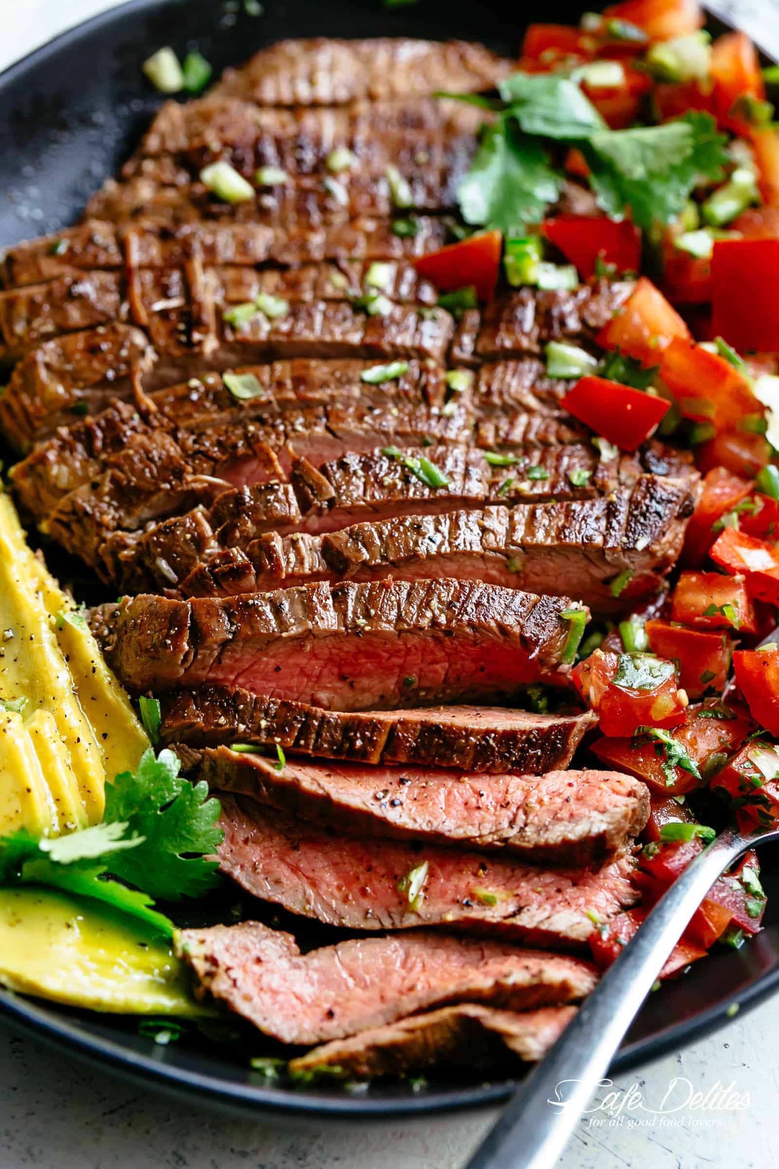 Carne Asada prepared with a deliciously easy and authentic marinade just in time for your Cinco De Mayo menu planning! Juicy and tender grilled flank or skirt steak full of incredible Mexican flavours makes this homemade Carne Asada recipe better than any restaurant! | cafedelites.com