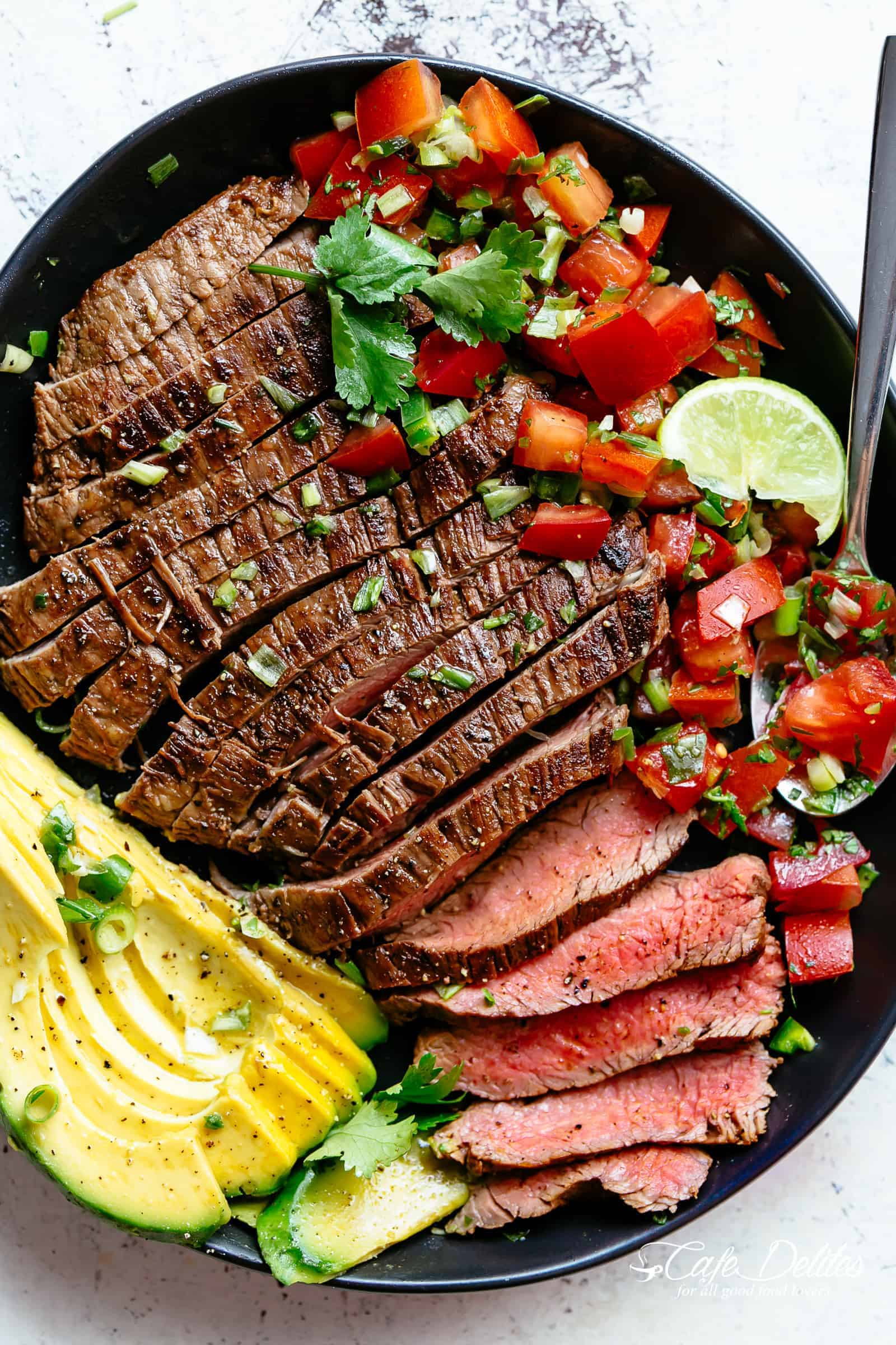 Carne Asada prepared with a deliciously easy and authentic marinade just in time for your Cinco De Mayo menu planning! Juicy and tender grilled flank or skirt steak full of incredible Mexican flavours makes this homemade Carne Asada recipe better than any restaurant! | cafedelites.com