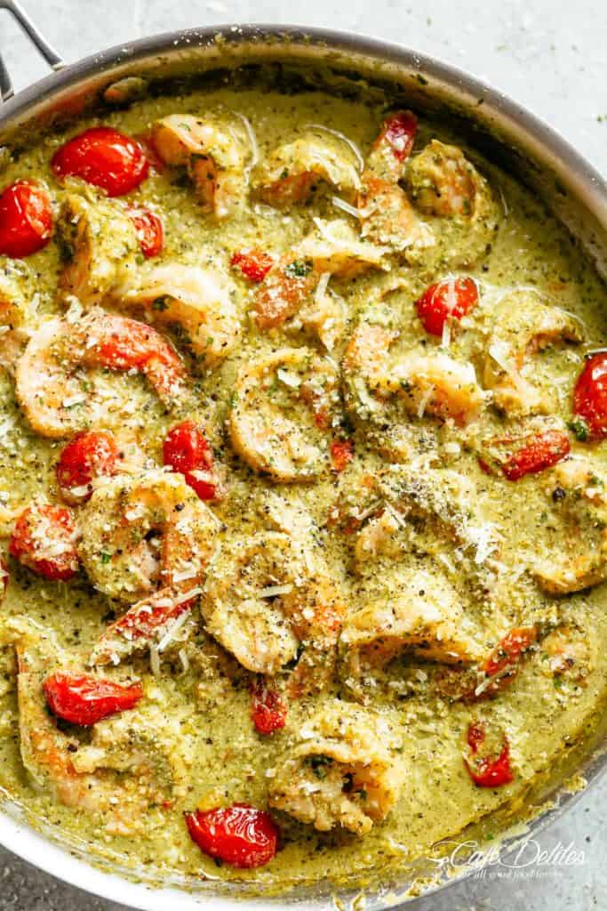 Creamy Pesto Shrimp Alfredo with parmesan cheese and blistered tomatoes is the shrimp recipe of your dreams! Ready in less than 10 minutes, gluten free AND low carb! Serve over zucchini noodles or cauliflower rice (OR pasta if you're not watching your carb intake)! | cafedelites.com