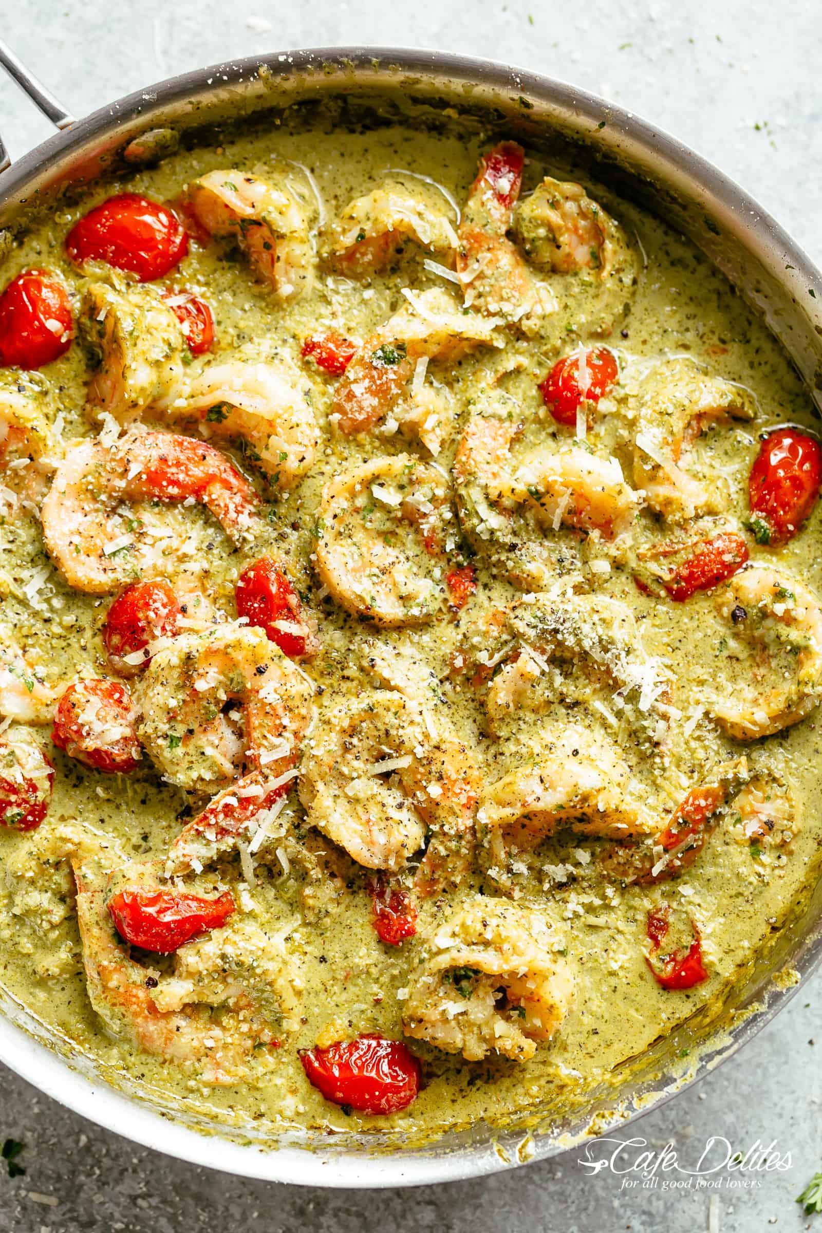 Creamy Pesto Shrimp Alfredo with parmesan cheese and blistered tomatoes is the shrimp recipe of your dreams! Ready in less than 10 minutes, gluten free AND low carb! Serve over zucchini noodles or cauliflower rice (OR pasta if you're not watching your carb intake)! | cafedelites.com