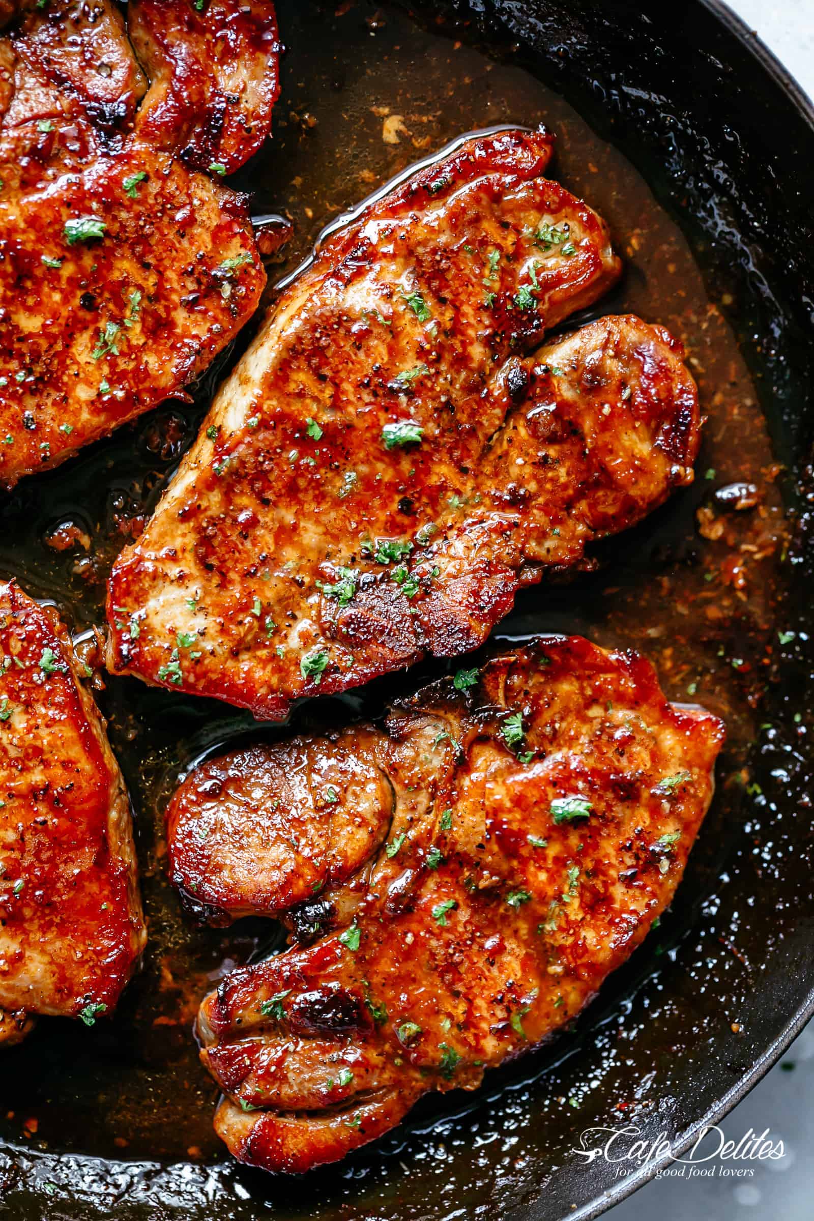 Easy Honey Garlic Pork Chops made simple, with the most amazing and addictive 4-ingredient honey garlic sauce in a black skillet